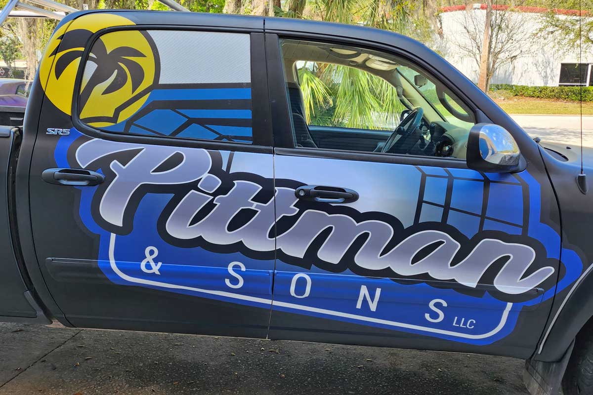 Truck door with "Pittman & Sons LLC" logo in large letters, palm tree graphic, and blue-yellow color scheme.