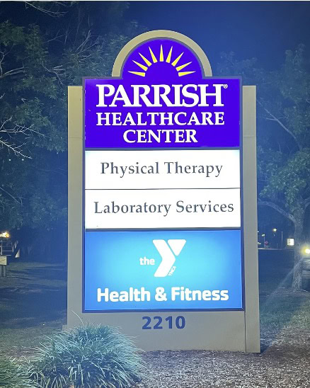 Illuminated sign for Parrish Healthcare Center listing physical therapy, laboratory services, and the YMCA health and fitness center at address 2210.